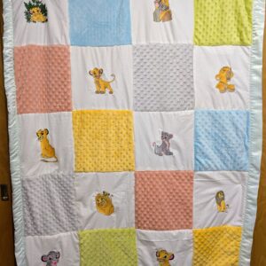 Handmade patchwork baby quilt featuring embroidered Lion King characters, textured minky squares, and a mint green satin ruffle border.